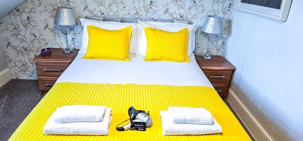 a bedroom with a yellow bed with yellow pillows at mySTAYINN Kinloch Lodge in Inverness
