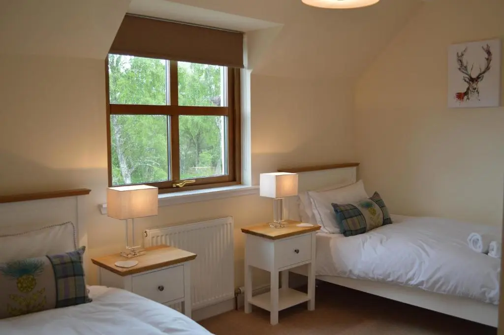 a bedroom with two beds and a window at Woodlands in Aviemore