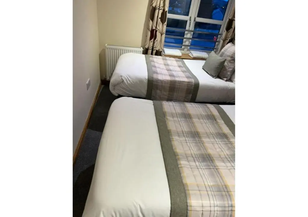 a pair of beds in a hotel room at The Waverley Inn Holiday Homes in Inverness