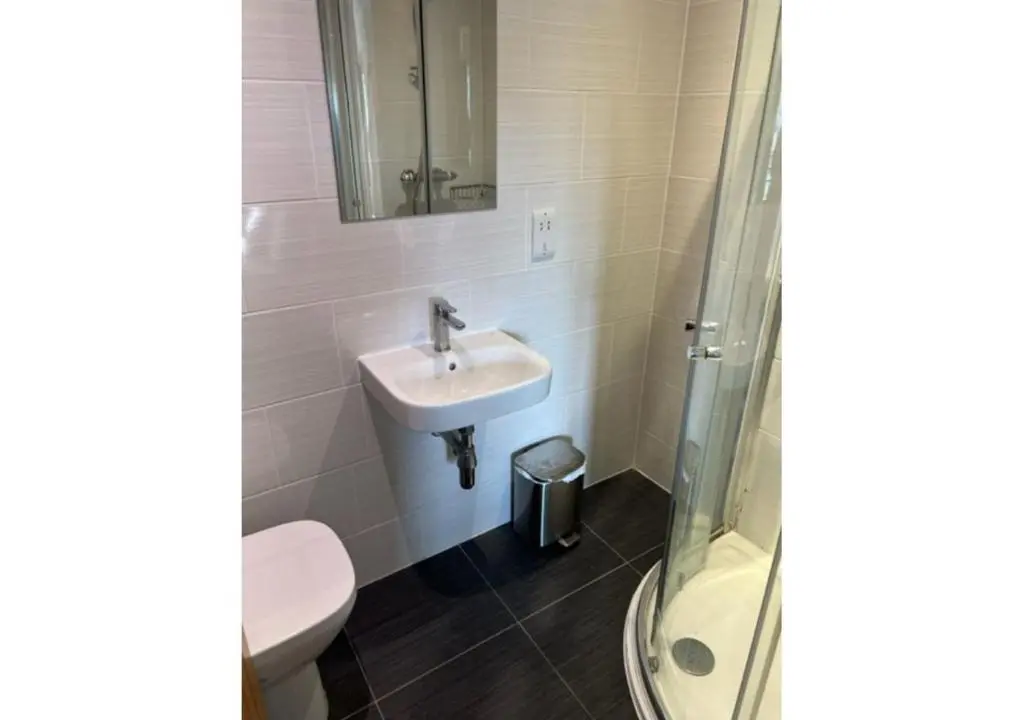 a bathroom with a toilet and a sink and a shower at The Waverley Inn Holiday Homes in Inverness