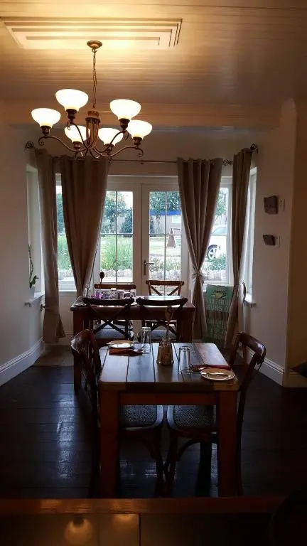 a dining room with a table with chairs and a chandelier at The Ship Inn in Invergordon