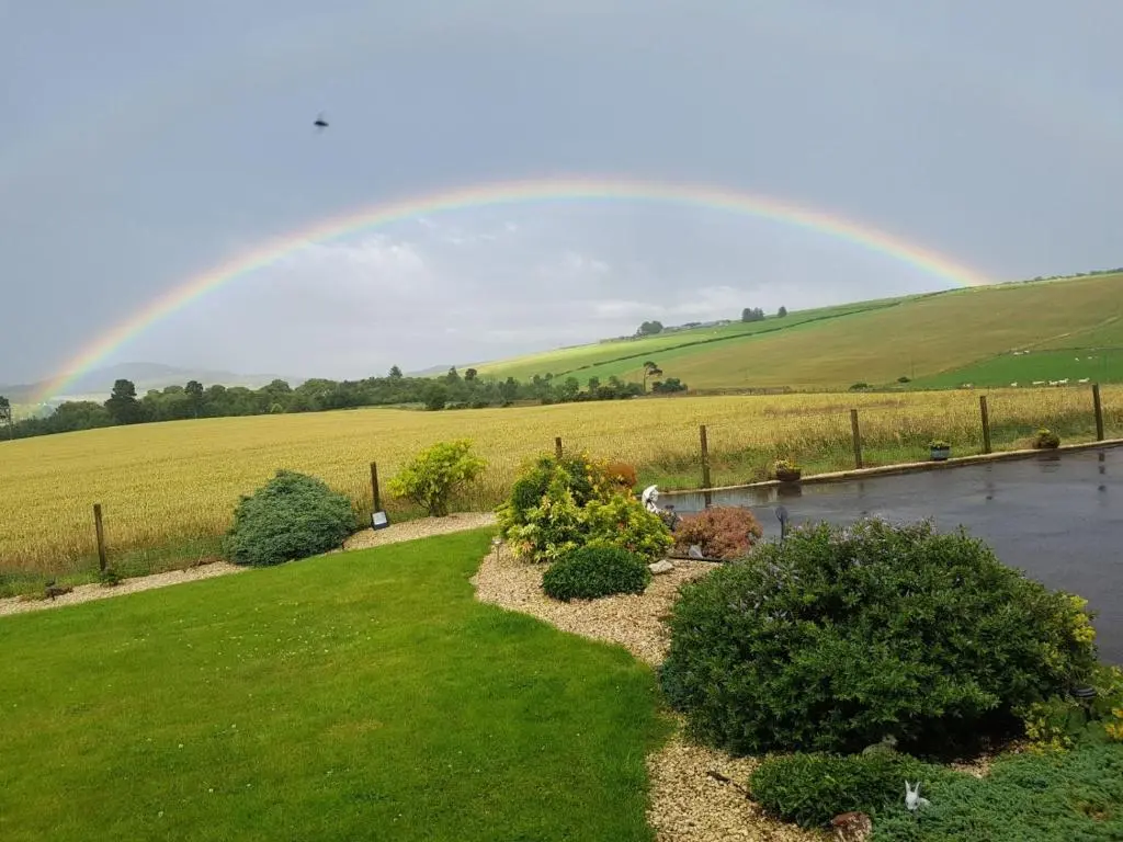 a rainbow over a field and a yard with a rainbow at Hillhaven Bed &Breakfast in Fortrose