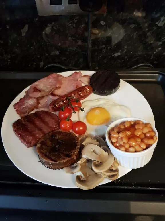 a plate of breakfast food with eggs meat and mushrooms at Hillhaven Bed &Breakfast in Fortrose
