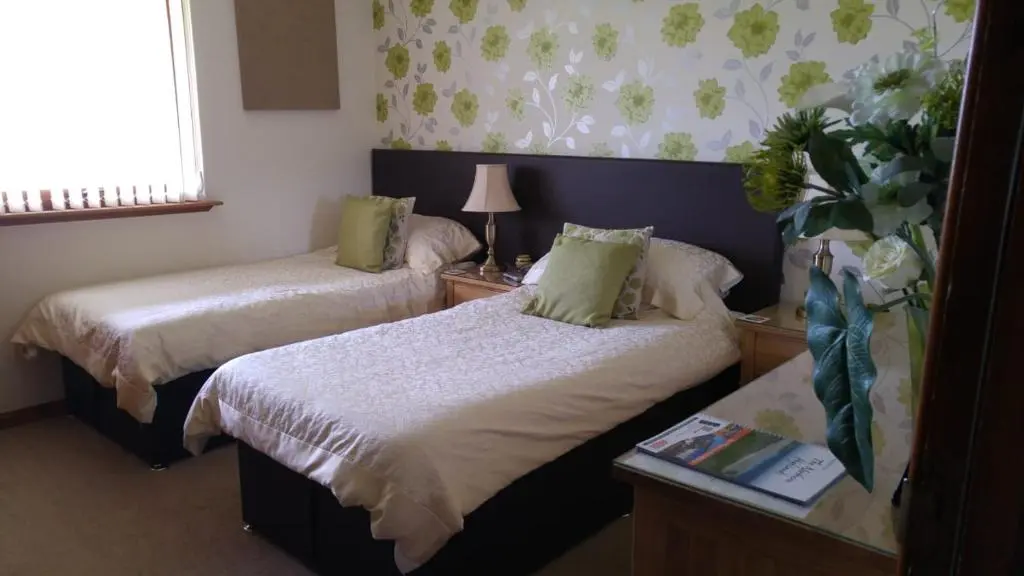 a hotel room with two beds and a window at Hillhaven Bed &Breakfast in Fortrose