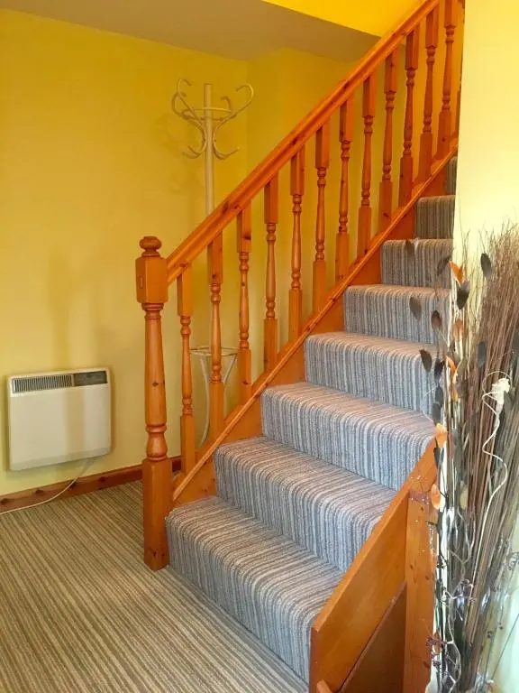a set of stairs in a living room with a stair at White Cottage B&B in North Kessock