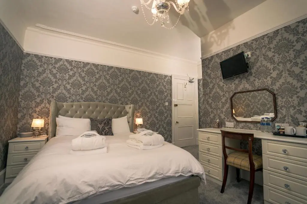 a bedroom with a bed and a desk and a mirror at Foyers Bay Country House in Foyers