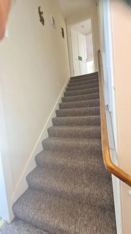 a staircase in a house with grey carpet at East Wing Apartment in Elgin in Elgin
