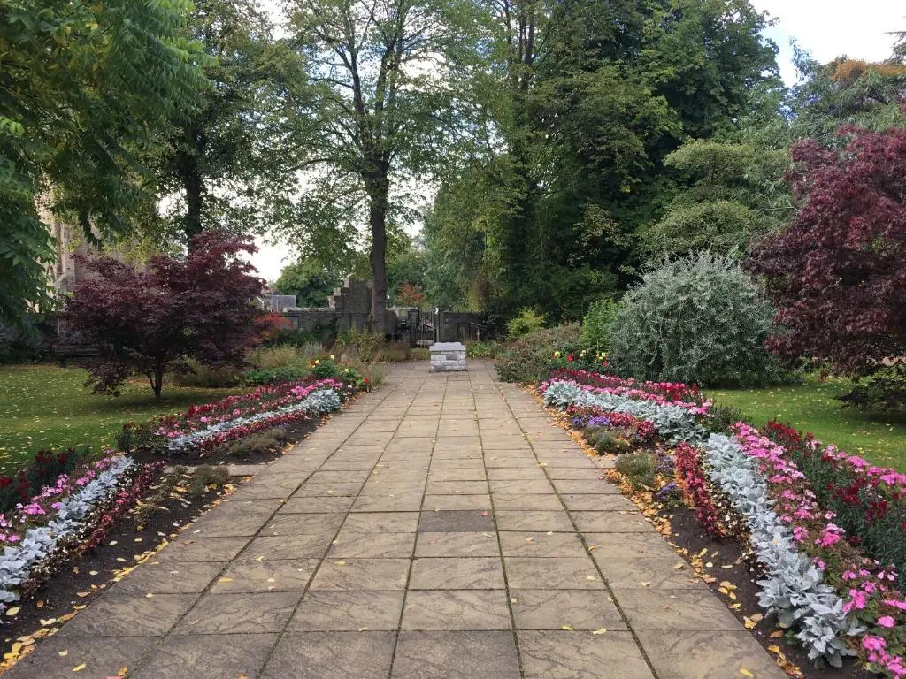a stone walkway in a park with flowers at Distillery Apartment 1 in Elgin