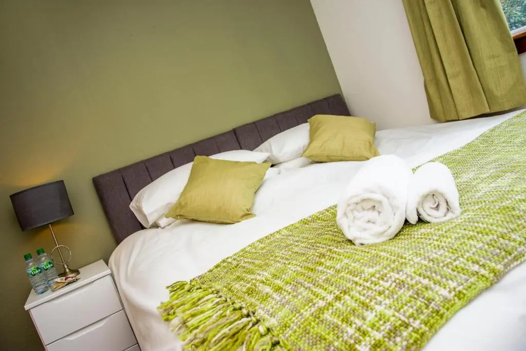 a bedroom with a bed with towels on it at Distillery Apartment 1 in Elgin