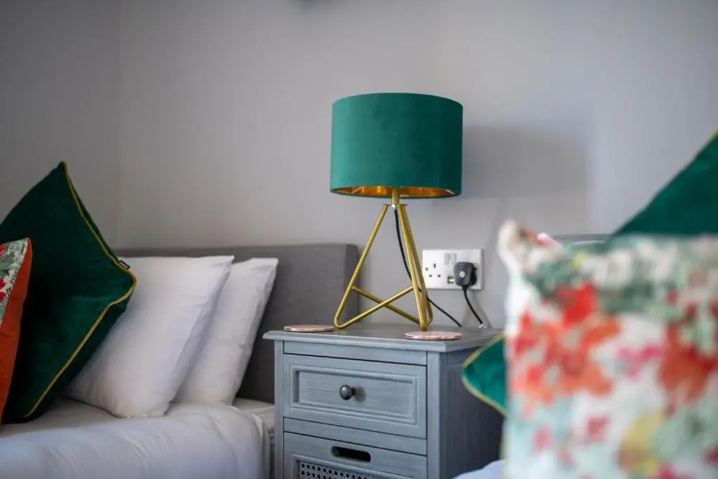 a lamp on a night stand next to a couch at Dryburgh Town House in Inverness