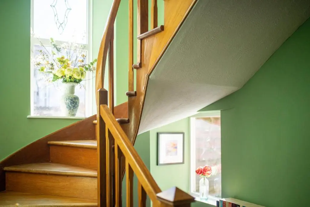 a staircase with a vase of flowers in a window at Dryburgh Town House in Inverness