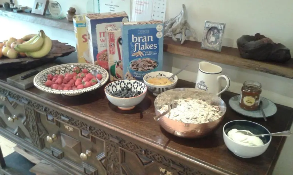 a counter with bowls of cereal and other food on it at Sunrise House in Inverfarigaig