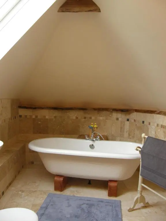 a bathroom with a bath tub in the attic at Sunrise House in Inverfarigaig