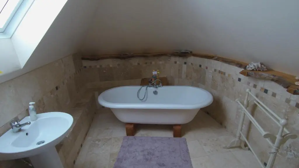 a bathroom with a sink and a bath tub at Sunrise House in Inverfarigaig