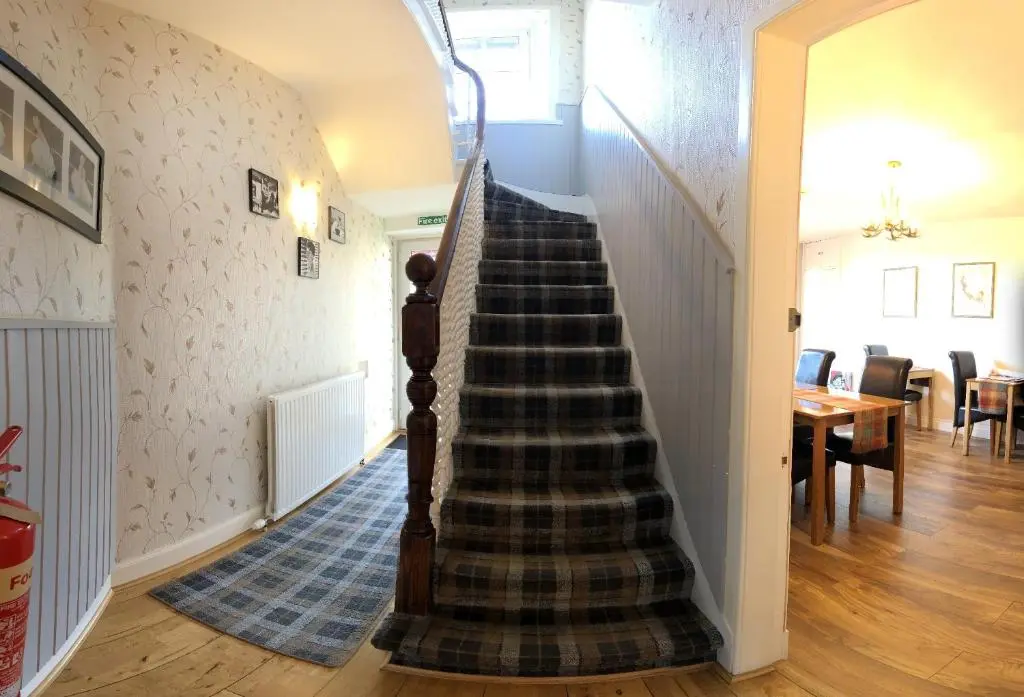 a spiral staircase in a house with a dining room at Carisbrooke Guest House in Inverness