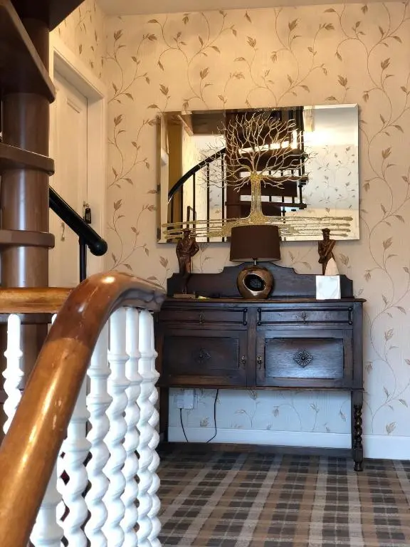 aoyer with a wooden dresser and a mirror at Carisbrooke Guest House in Inverness