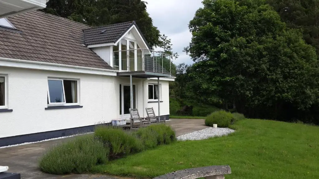 a house with a balcony on the side of it at High March in Drumnadrochit