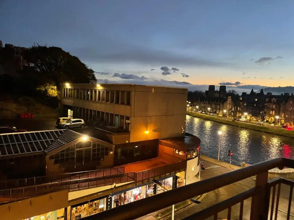 a building next to a river at night at Apartment 306 By the Bridge in Inverness