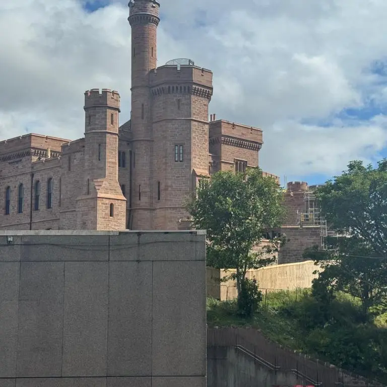 a castle with two towers on top of a building at Apartment 306 By the Bridge in Inverness