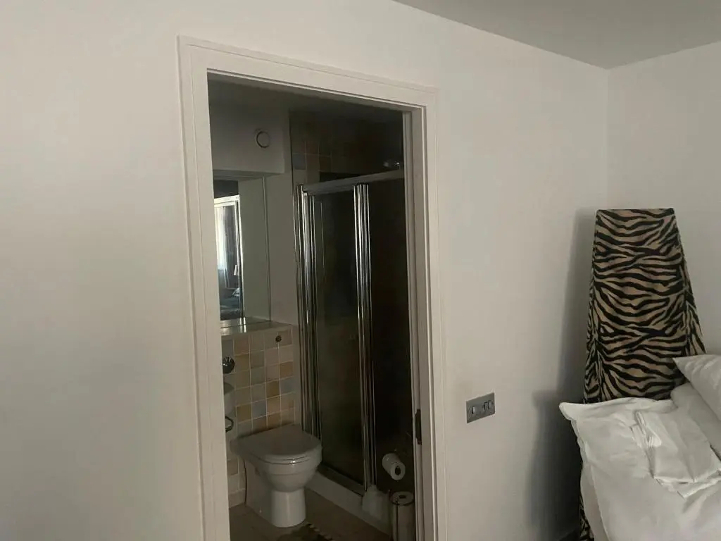 a bathroom with a toilet and a glass shower at Apartment 306 By the Bridge in Inverness