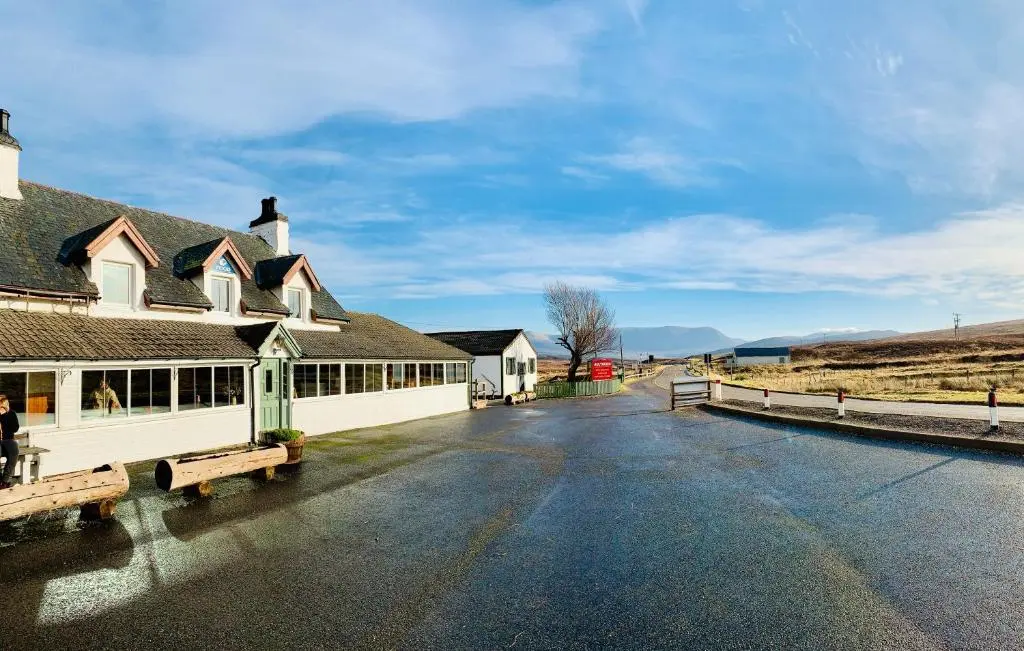 a building with two benches in the middle of a street at Aultguish Inn in Garve