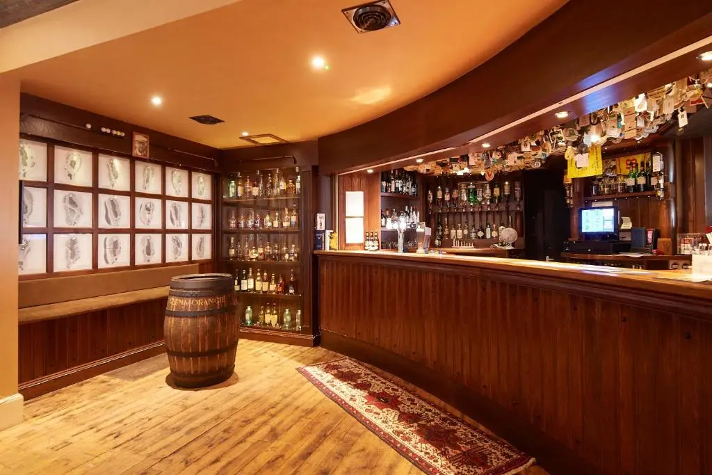 a bar with a barrel in the middle of it at Royal Golf Hotel, by Highland Coast Hotels in Dornoch
