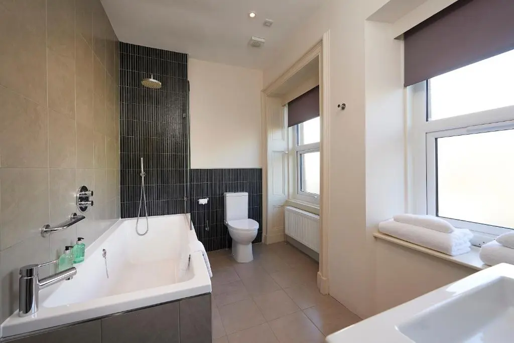 a bathroom with a tub and a toilet and a sink at Royal Golf Hotel, by Highland Coast Hotels in Dornoch