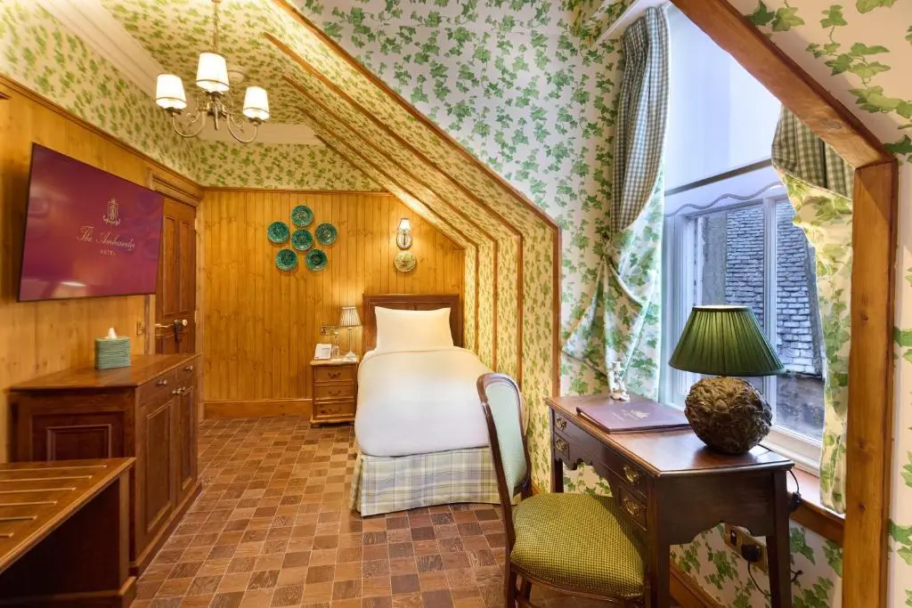 a bedroom with a bed and a desk in a room at The Ambassador Hotel in Inverness
