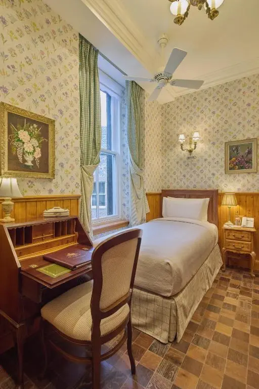 a bedroom with a bed and a desk and a desk at The Ambassador Hotel in Inverness