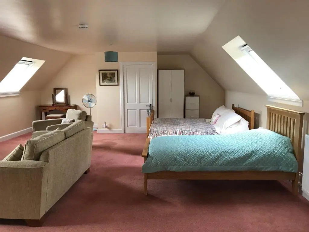 a attic bedroom with a bed and a couch at Whitehill in Finzean