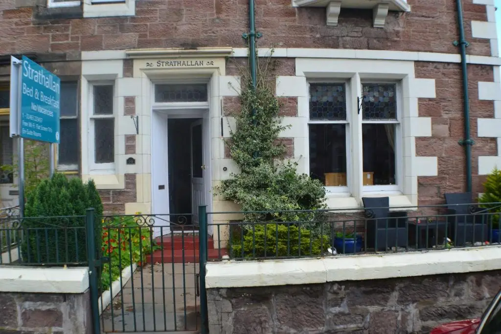 a brick house with a sign in front of it at Strathallan B&B in Inverness
