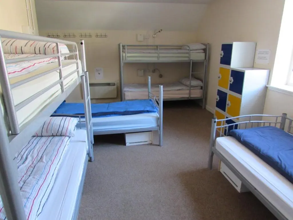 a room with three bunk beds in a room at Ballater Hostel in Ballater