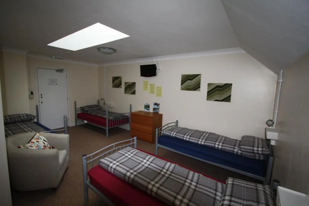 a dorm room with two bunk beds and a couch at Ballater Hostel in Ballater