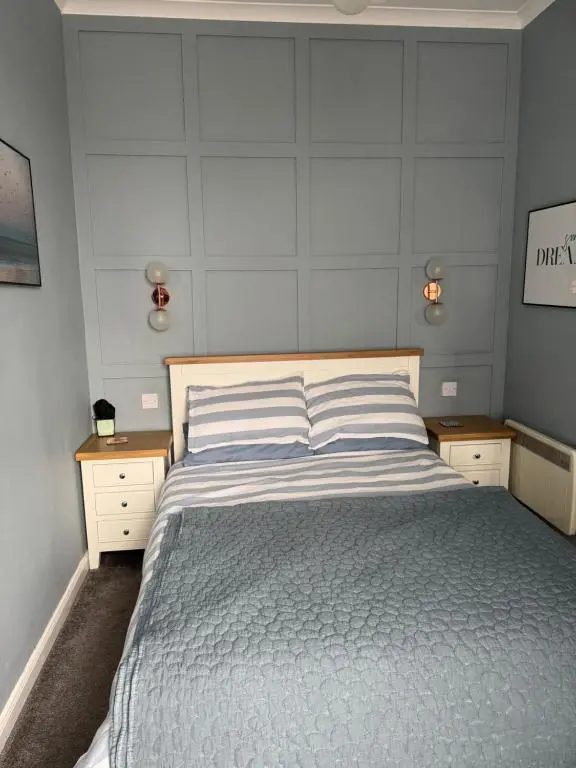 a bedroom with a large bed with two night stands at Harbour quay in Wick