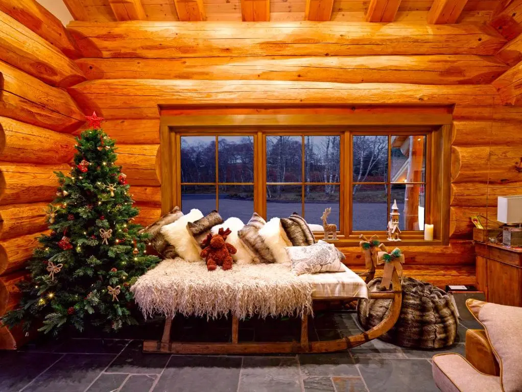 a log cabin with a christmas tree and a couch at Caledonian Cabin in Invergarry