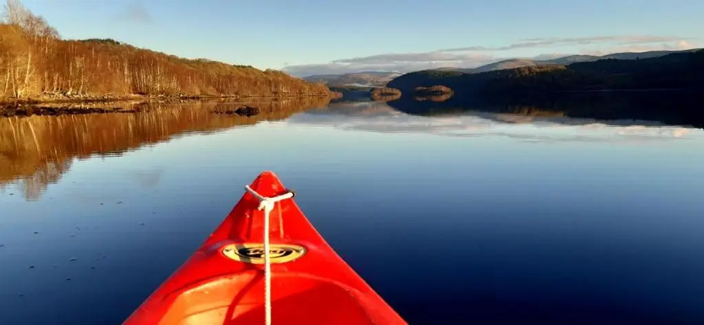 a red kayak on a body of water at Caledonian Cabin in Invergarry