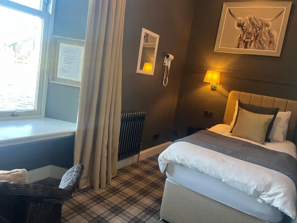 a hotel room with a bed and a window at Fraser House in Inverness