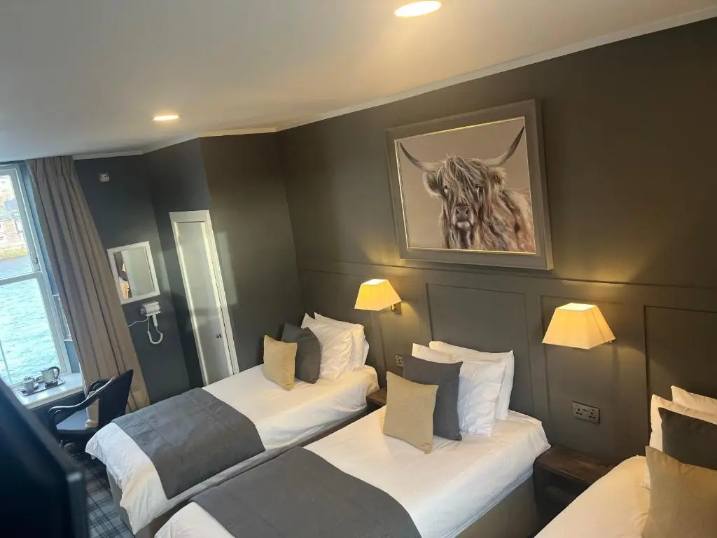 a hotel room with two beds and a picture of a horse at Fraser House in Inverness