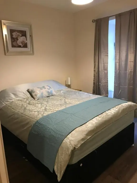 a large bed in a bedroom with a window at River Ness Apartments in Inverness