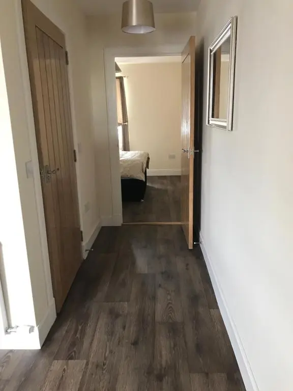 a hallway of a room with a door and a bedroom at River Ness Apartments in Inverness