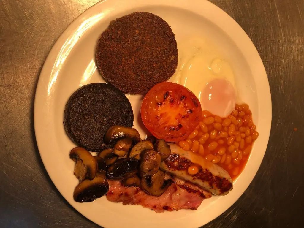 a plate of food with eggs beans and mushrooms at Belgrave Arms Hotel in Helmsdale