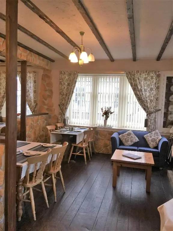 a living room with a table and chairs and a couch at Belgrave Arms Hotel in Helmsdale