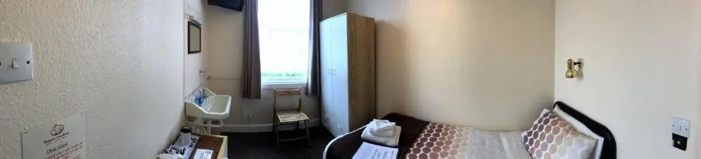 a bathroom with a sink and a toilet and a mirror at Belgrave Arms Hotel in Helmsdale