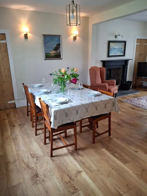 a dining room with a table with flowers on it at Aberlour Cottages - Bolthole & Retreat in Aberlour