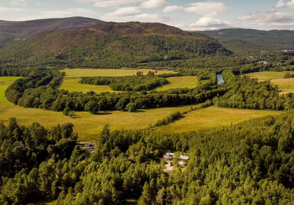 an aerial view of a valley with trees and a river at Cairngorm Lodge Rothiemurchus in Aviemore