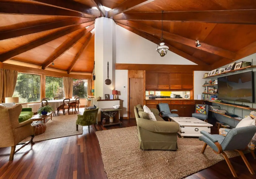 a living room with wooden ceilings and a living room with furniture at Cairngorm Lodge Rothiemurchus in Aviemore