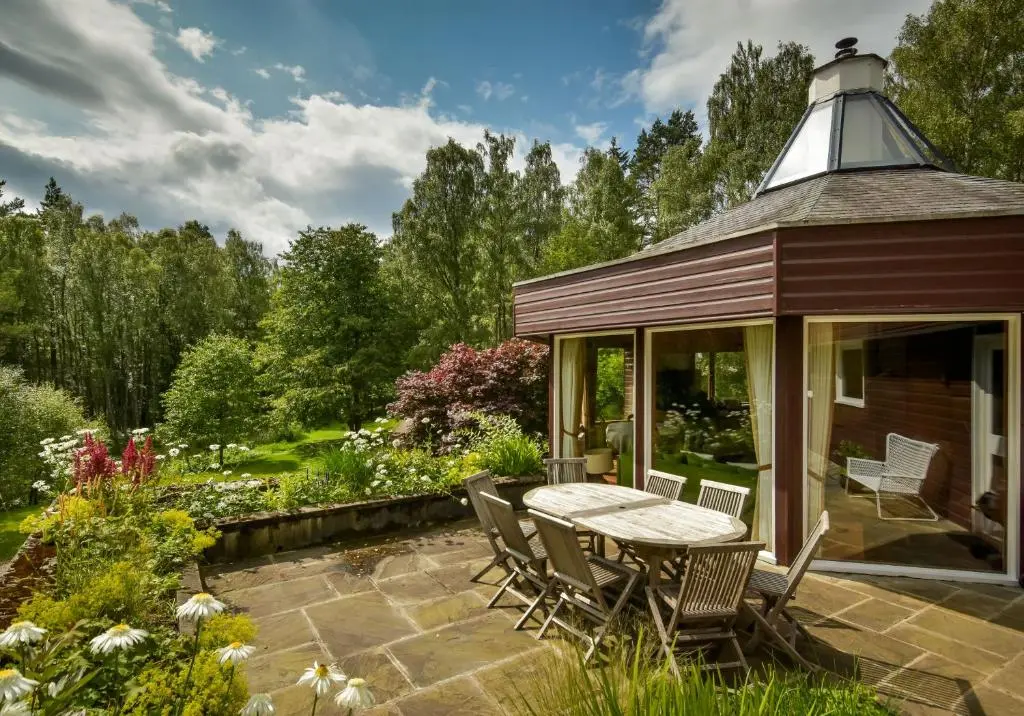 a gazebo with a table and chairs in a garden at Cairngorm Lodge Rothiemurchus in Aviemore