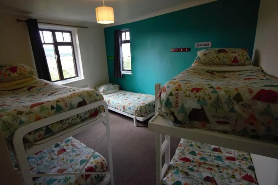 two bunk beds in a room with green walls at Inverness Student Hotel in Inverness
