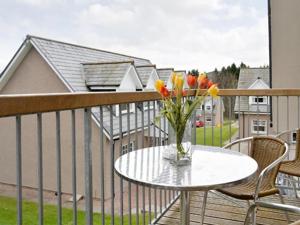 a vase of flowers sitting on a table on a balcony at 22 Queens Court in Inchmarlo