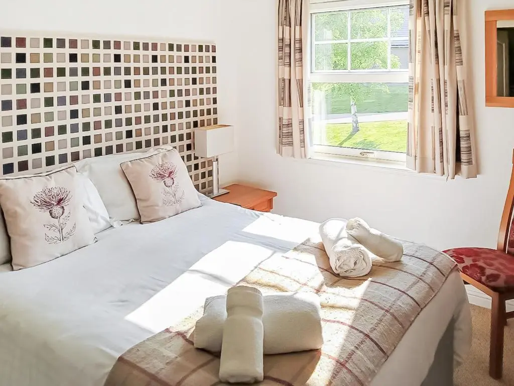a bedroom with a white bed with towels on it at 22 Queens Court in Inchmarlo